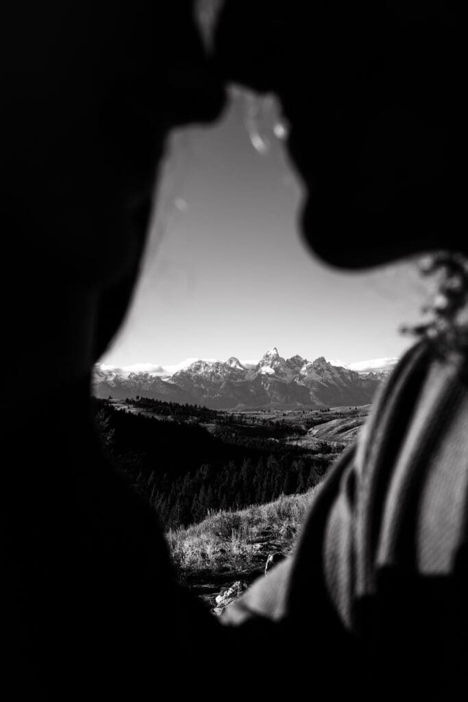 View of the Grand Tetons framed by man and woman in black and white.