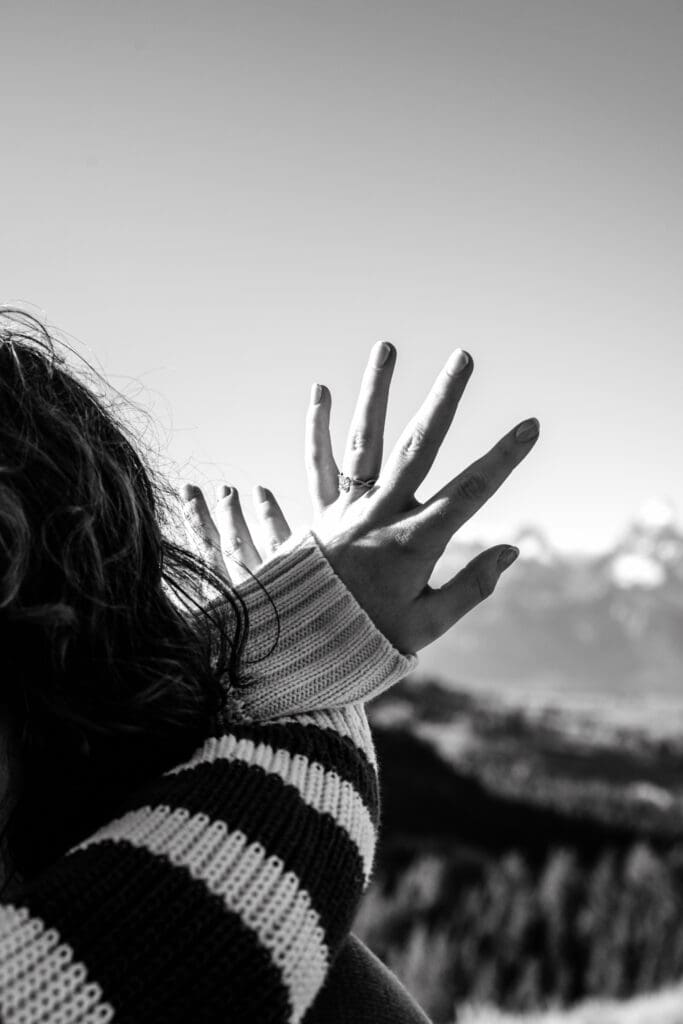 Woman admiring ring in front of vieView of the Grand Tetons framed by man and woman of the Grand Tetons.