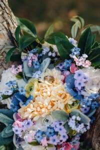 Bride and groom's rings resting on colorful spring bouquet in Idaho Falls.