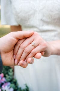 Bride's wedding ring on her finger as groom takes her hand in Idaho Falls.