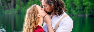 Man and woman kiss with man's hands on woman's chin, captured by Utah engagement photographer.
